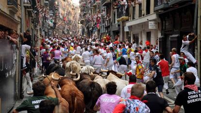 Un grupo de corredores avanza delante de los toros a su paso por la calle Estafeta, en Pamplona, en 2016.