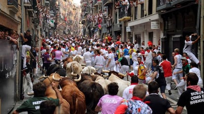 Un grupo de corredores avanza delante de los toros a su paso por la calle Estafeta, en Pamplona, en 2016.