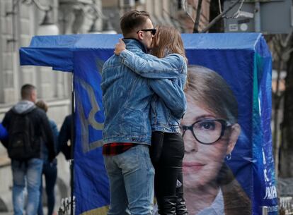 Una pareja se besa frente a un cartel preelectoral de la líder de la oposición del partido Batkivshchyna y candidata presidencial, Yulia Tymoshenko, en el centro de Kiev (Ucrania), el 25 de marzo.