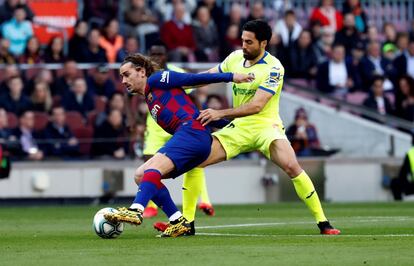 El defensa Xabier Etxeita intenta detener el ataque del delantero francés del Barça Antoine Griezmann durante el partido correspondiente a la jornada 24ª de LaLiga Santander, que se disputa este sábado en el Camp Nou de Barcelona.