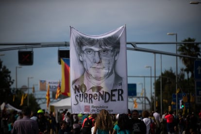 Los integrantes de una de las marchas portan una pancarta con un retrato del expresidente catalán Carles Puigdemont, huido de la justicia en Bélgica, en la que se puede leer 'No surrender' (no rendirse), a su llegada a Barcelona.
