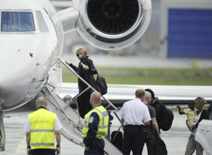 Madonna y sus hijos suben al avión ayer en Helsinki.