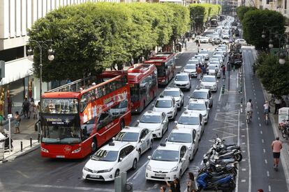 Taxistas de València han parado sus vehículos a última hora de la mañana de en los dos carriles centrales de la calle Colón, en la que se encuentra la sede de la Delegación del Gobierno, como protesta por la proliferación de licencias VTC.