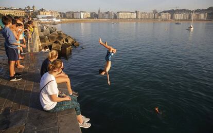 Un grupo de jóvenes se baña en el puerto de San Sebastian