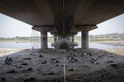 Decenas de personas duermen bajo el puente del río Yamuna en Nueva Delhi, el 22 de mayo.