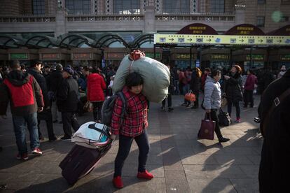 Una mujer carga con su equipaje de camino a la estación de tren de Pekín antes de coger un tren que le lleve a su hogar para celebrar el Festival de Primavera en Pekín (China), el 1 de febrero de 2018. 