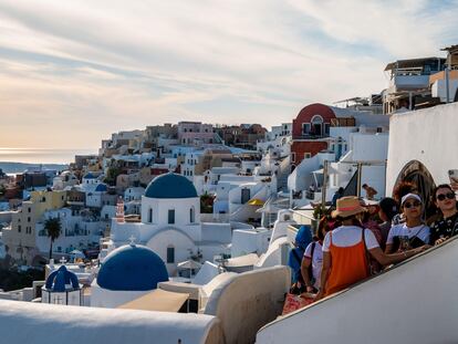 Turistas tomando fotografías y selfis en la ciudad de Oia (Santorini) ante sus casas encaladas e iglesias con cúpulas azules.