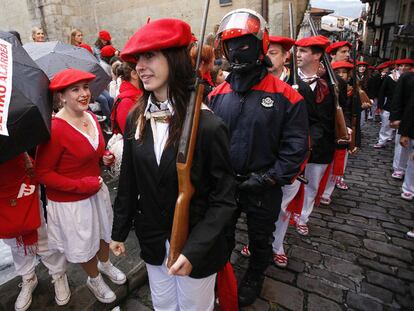 Miembros del Alarde mixto, custodiados por la Ertzaintza, son recibidos en Hondarribia con abucheos y paraguas negros.