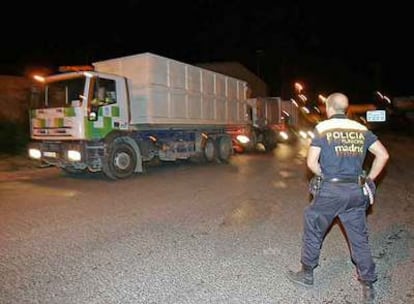 Un policía municipal vigila la salida de camiones de recogida de basura en Valdemingómez.