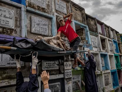 Trabajadores funerarios exhuman el cadáver de una de las víctimas de la guerra contra las drogas para incinerarlo tras terminarse el alquiler del nicho en el que se encontraba.