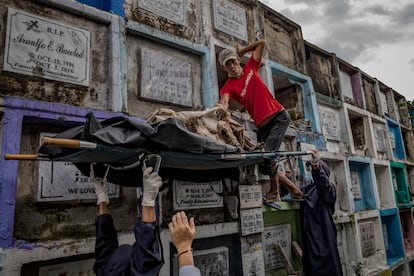 Trabajadores funerarios exhuman el cadáver de una de las víctimas de la guerra contra las drogas para incinerarlo tras terminarse el alquiler del nicho en el que se encontraba.