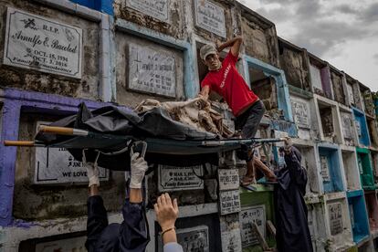 Trabajadores funerarios exhuman el cadáver de una de las víctimas de la guerra contra las drogas para incinerarlo tras terminarse el alquiler del nicho en el que se encontraba.