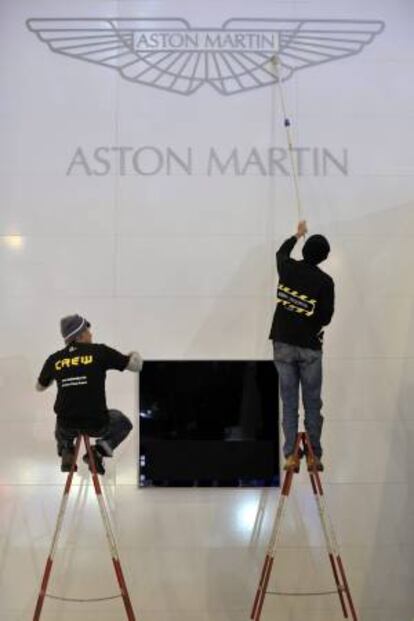 Dos empleados de Aston Martin limpian el logotipo. EFE/Archivo