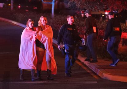 Dos mujeres envueltas en una sábana abandonan el área del tiroteo cerca del bar Borderline, en Thousand Oaks, un suburbio en las afueras de Los Ángeles (California).