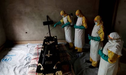 Varios sanitarios desinfectan el ataúd de una posible víctima de ébola en República Democrática del Congo, el pasado diciembre.