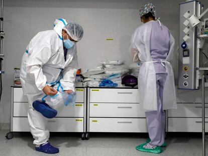 En la imagen,personal sanitario se prepara con EPIS en la Unidad de Cuidados Intensivos del Hospital La Fe de Valencia.