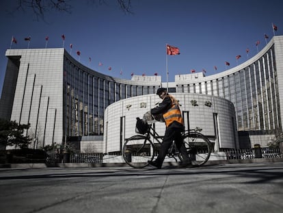 Un hombre pasa por delante de la sede del Banco Popular de China, en Pek&iacute;n.