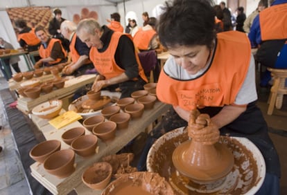 Varios alfareros trabajan el barro en Zegama.