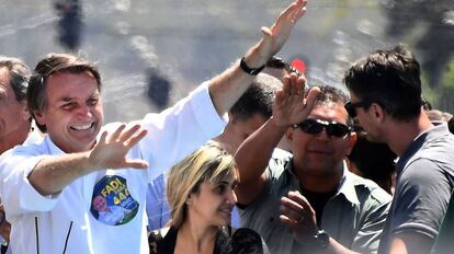 Bolsonaro ladeado por três policiais em carreata em Brasília, no dia 5.