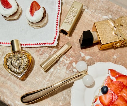 Desde la izda., Devotion Eau de Parfum de DOLCE & GABBANA (en formato para llevar, de 20 ml), perfume sólido en barra J’adore l’Or de DIOR, edición limitada Libre Vanille Couture de YVES SAINT LAURENT y masajeador gua sha con esferas de cuarzo Precious Le Roll-On de CLARINS.Servilleta navideña y plato Bourgeoisie, ambos de MAISONS DU MONDE.