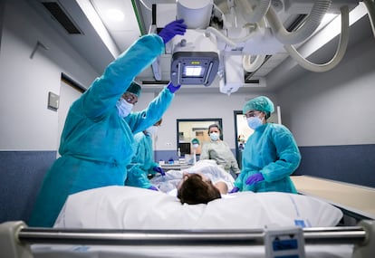 Varios sanitarios de la unidad de radiología preparan a una paciente para una placa de torax. 