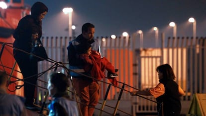 Un policía de Frontex baja al puerto de Algeciras a un bebé que viajaba en la embarcación Arcturus de Salvamento Marítimo.