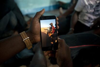 Ju Dennis, de Liberia, sostiene su teléfono. Con él filmó su situación en el Sáhara después de haber sido expulsado de Argelia. El pasado 1 de junio, cuando se tomó esta fotografía, el chico se encontraba enun campamento de la Organización Internacional para la Migración en la ciudad de Arlit, en el norte del país. Dennis grabó su deportación con un teléfono móvil que mantuvo oculto en su cuerpo. "Nos arriesgamos a la deportación en Argelia, no hay piedad", dice. "Quiero mostrarlo: Estamos aquí, vimos lo que hicieron. Y tenemos pruebas".  