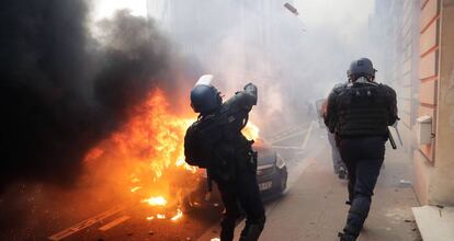 TOPSHOT - A riot police throws tear gas during a protest of