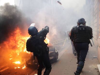 TOPSHOT - A riot police throws tear gas during a protest of