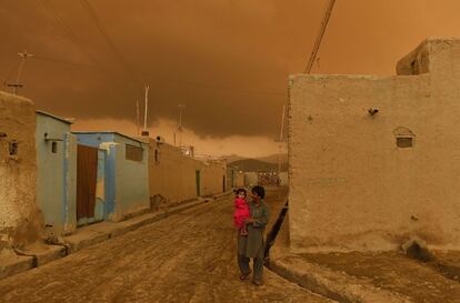 Un padre afgano carga a su hija momentos antes de una tormenta, el 19 de abril de 2015, en Kabul.