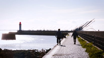 Dos ciudadanos pasean por el muelle de Saint-Nazaire.