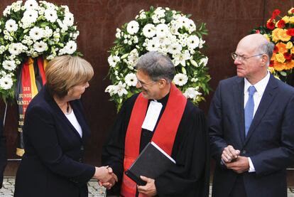 La canciller alemana, Angela Merkel, saluda al Pastor Fisher acompañada por el presidente del Parlamento alemán, Norbert Lammert, al comienzo de la ceremonia en Berlín