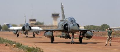 Un soldado dirige a dos aviones caza franceses Mirage tras su aterrizaje el jueves en el aeropuerto de Bamako, capital de Mal&iacute;.