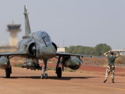 Un soldado dirige a dos aviones caza franceses Mirage tras su aterrizaje el jueves en el aeropuerto de Bamako, capital de Mal&iacute;.