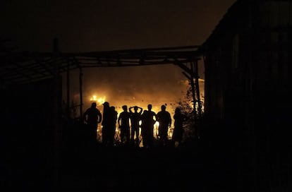 Um grupo observa as casas afetadas pelo incêndio em um dos morros da cidade de Valparaíso.