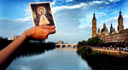 Una estampa de la Virgen sobre el Ebro a su paso por Zaragoza. A la derecha, la basílica del Pilar.