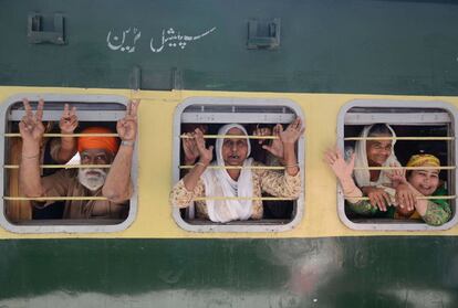 Los peregrinos sijs indios saludan con la mano desde un tren en la estación de Attari antes de partir a Lahore para celebrar el festival de Baisakhi en Pakistán, en las afueras de Amritsar (India).