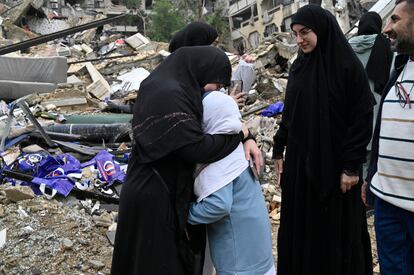 Varias personas reaccionan, junto a los escombros de un edificio, tras la entrada en vigor del alto el fuego con Israel, en el distrito de Dahiye, en el sur de Beirut.