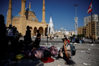 Familias desplazadas se reúnen después de pasar la noche en la plaza de los Mártires, en el centro de Beirut, huyendo de los ataques israelíes nocturnos.