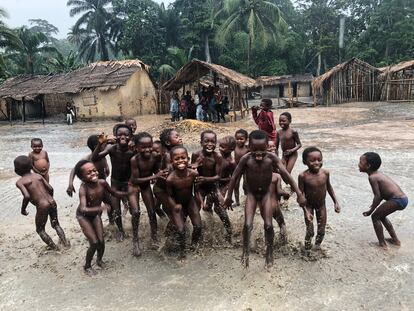 Los niños de una comunidad forestal remota juegan bajo la lluvia en el norte de la RDC. Sus aldeas tienen derechos de tenencia sobre los bosques, pero lamentan que, a menudo, su futuro se sella a 2.000 kilómetros, en las oficinas de altos cargos en Kinshasa.