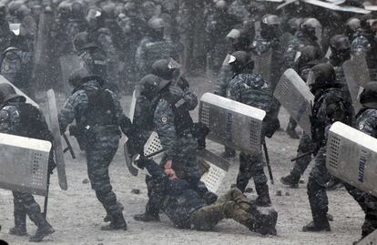 Agentes de la policía arrastran a un hombre durante los enfrentamientos con manifestantes pro-europeos en Kiev.