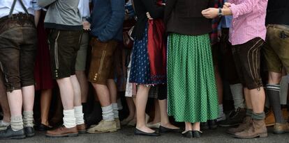 Visitantes con trajes tradicionales esperan la apertura de la tradicional Oktoberfest en Múnich (Alemania), el 20 de septiembre de 2014.