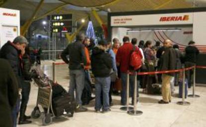 Varios viajeros hacen cola frente a la oficina de Iberia en la terminal 4 del aeropuerto de Barajas (Madrid). EFE/Archivo