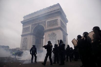 Casi 90 personas han sido arrestadas este sábado en Francia, 75 de ellas en la capital, durante una nueva jornada de movilizaciones del colectivo chalecos amarillos, en el noveno fin de semana consecutivo de protestas. En la imagen, policías antidisturbios montan guardia durante la manifestación del movimiento cerca del Arco de Triunfo en París.