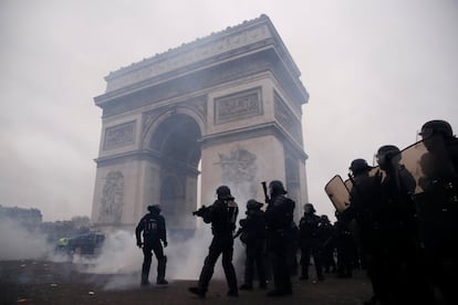 Casi 90 personas han sido arrestadas este sábado en Francia, 75 de ellas en la capital, durante una nueva jornada de movilizaciones del colectivo chalecos amarillos, en el noveno fin de semana consecutivo de protestas. En la imagen, policías antidisturbios montan guardia durante la manifestación del movimiento cerca del Arco de Triunfo en París.