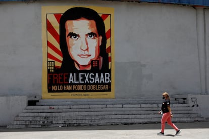 FILE PHOTO: A woman walks by a mural in support of the liberation of Colombian businessman and envoy Alex Saab, who is detained in Cape Verde on charges of laundering money for the government of Venezuelan President Nicolas Maduro, in Caracas, Venezuela September 9, 2021. REUTERS/Leonardo Fernandez Viloria/File Photo