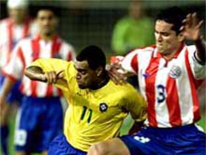 Denilson intenta resistir la entrada de un rival paraguayo.