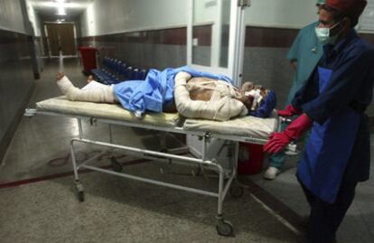 Un sanitario traslada en camilla a un herido por la explosión de una mina terrestre, en el hospital de Herat, Afganistán.