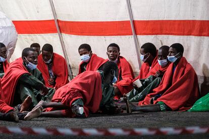 En la imagen, varios de los ocupantes del cayuco descansan en una tienda de campaña de Cruz Roja tras desembarcar en Arguineguín. 