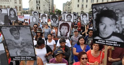 Manifestantes portan imágenes de las víctimas de los crímenes por los que fue condenado.